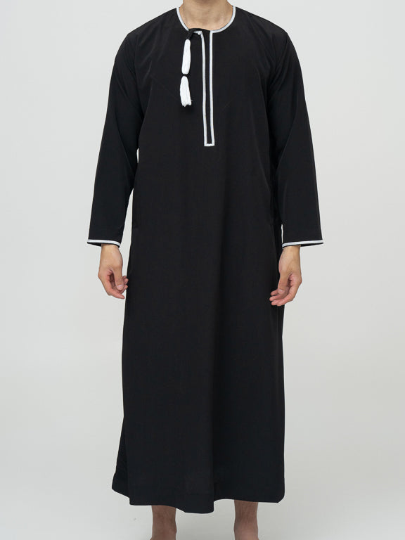 homme musulman portant un qamis omanais noir de face