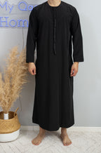 Homme musulman qui porte un Qamis émirati Dubai al emad noir de face