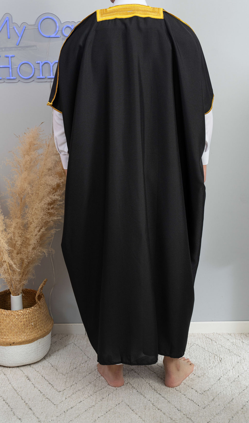 Homme arabe qui porte un Bisht noir de dos