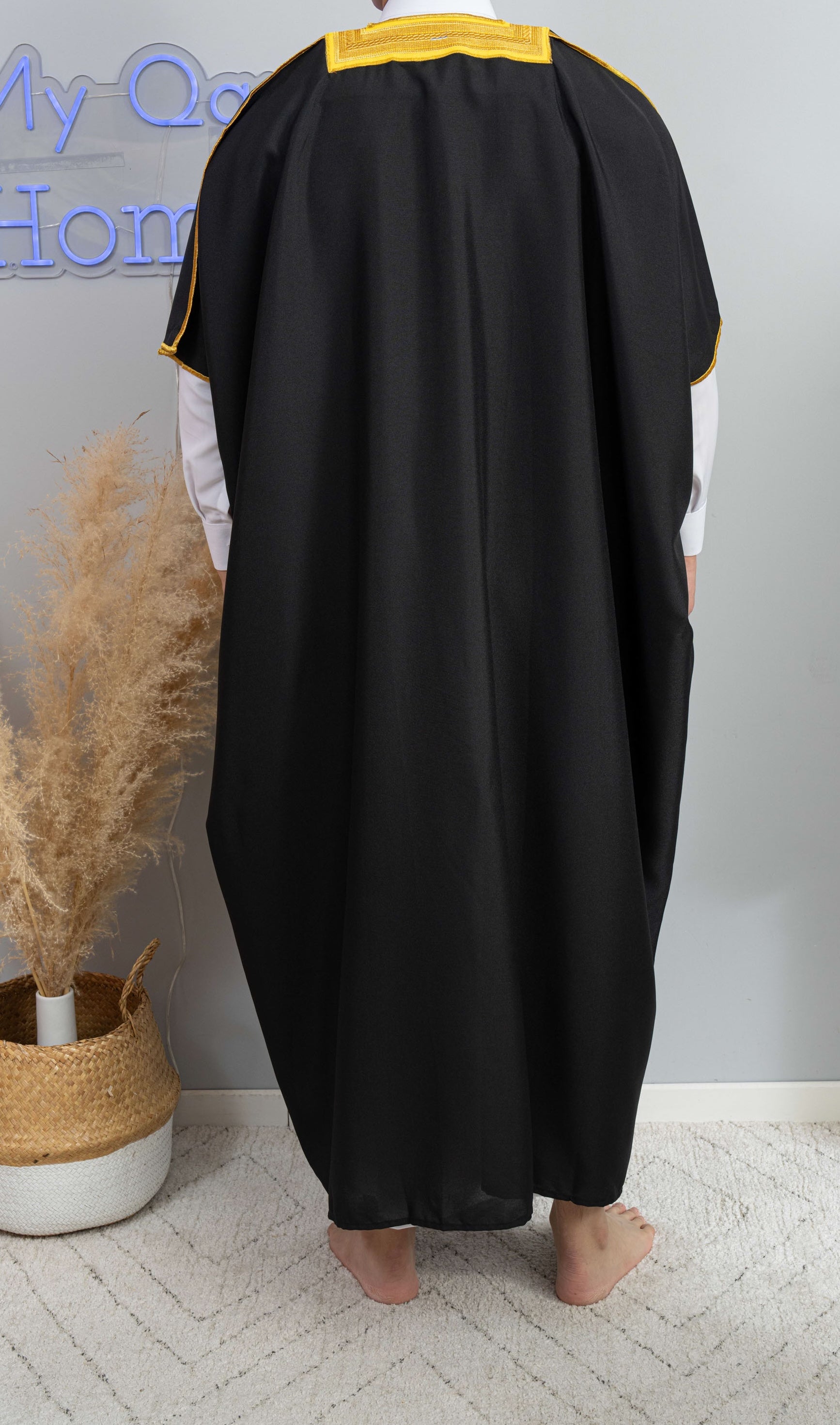 Homme arabe qui porte un Bisht noir de dos