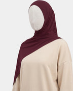 Hijab modal breathable bordeaux porté de profil, drapé fluide sur l'épaule, tissu doux et respirant
