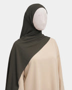 Hijab modal breathable kaki porté de profil, drapé fluide sur l'épaule, tissu doux et respirant
