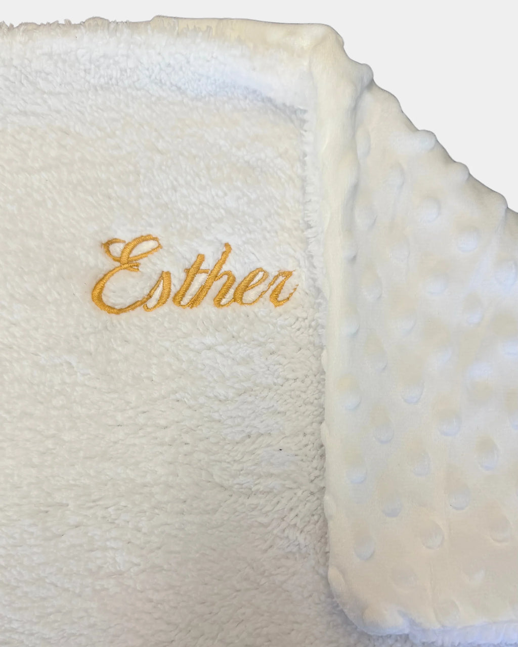 Détail de la broderie du prénom en fil doré sur plaid bébé personnalisé 100% coton