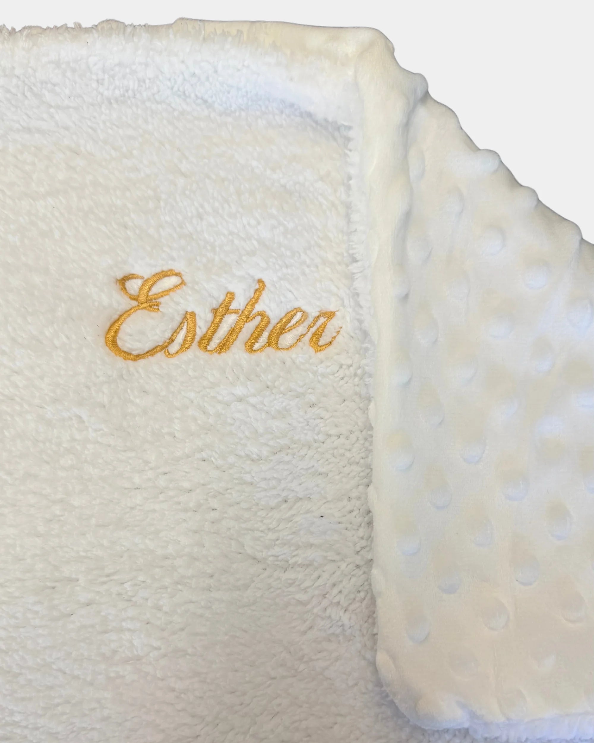 Détail de la broderie du prénom en fil doré sur plaid bébé personnalisé 100% coton