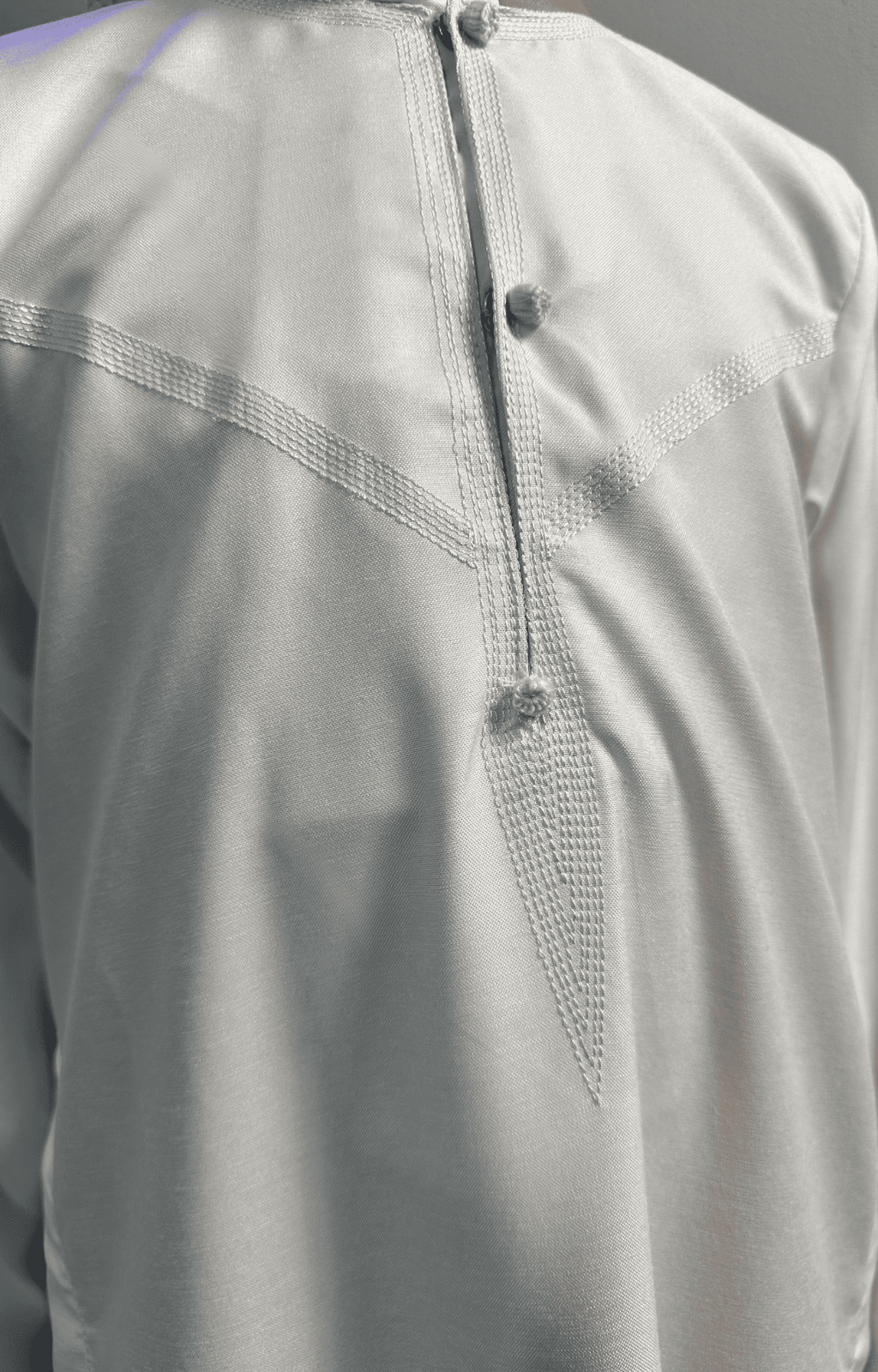 Garçon musulman portant un qamis enfant émirati al emad blanc avec broderie sur le col