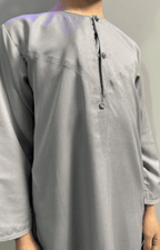 Garçon musulman portant un qamis enfant émirati al emad gris broderie sur le col