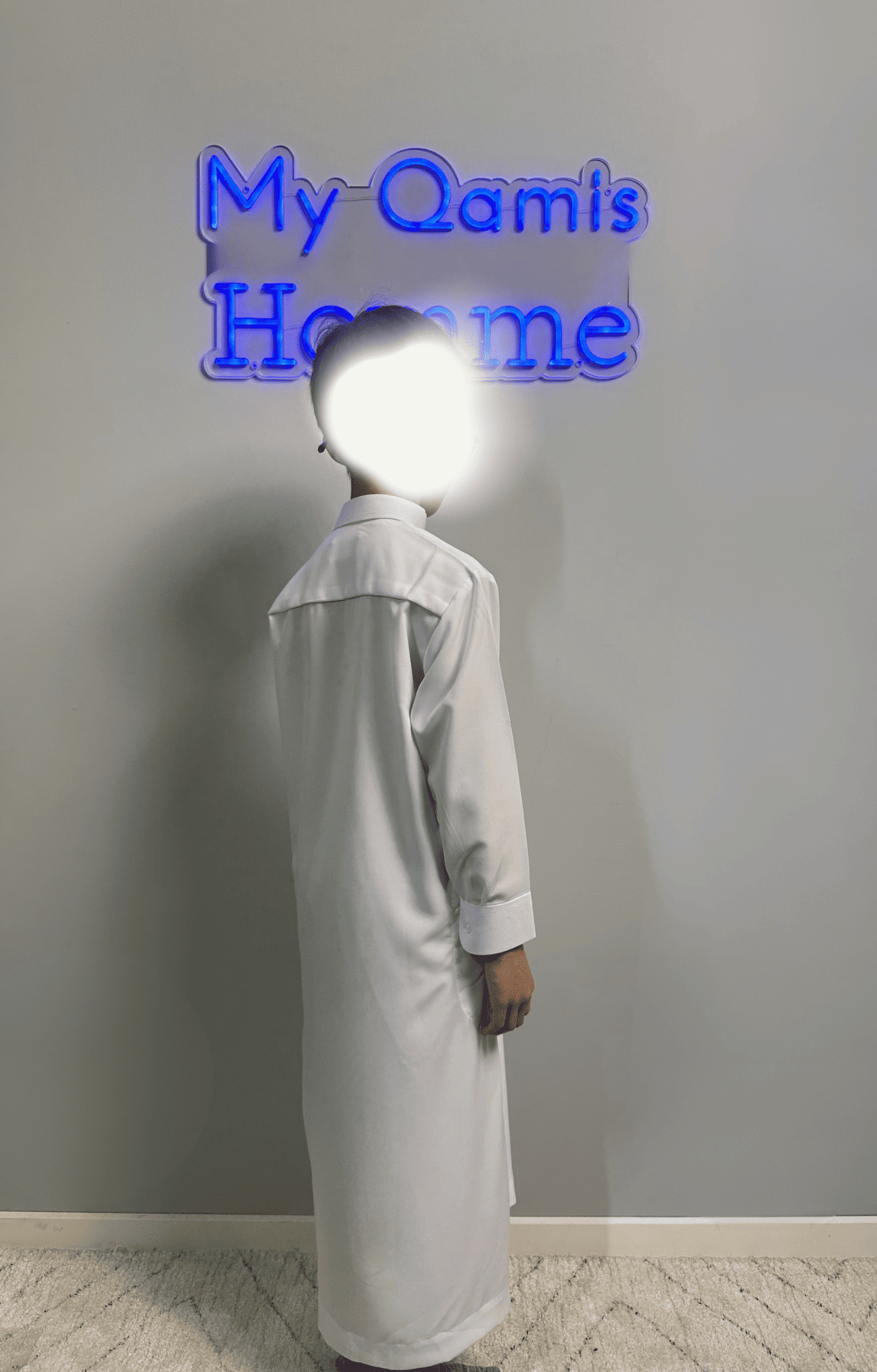 Garçon musulman portant un qamis enfant saoudien al emad blanc de dos