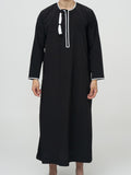homme musulman portant un qamis omanais noir de face