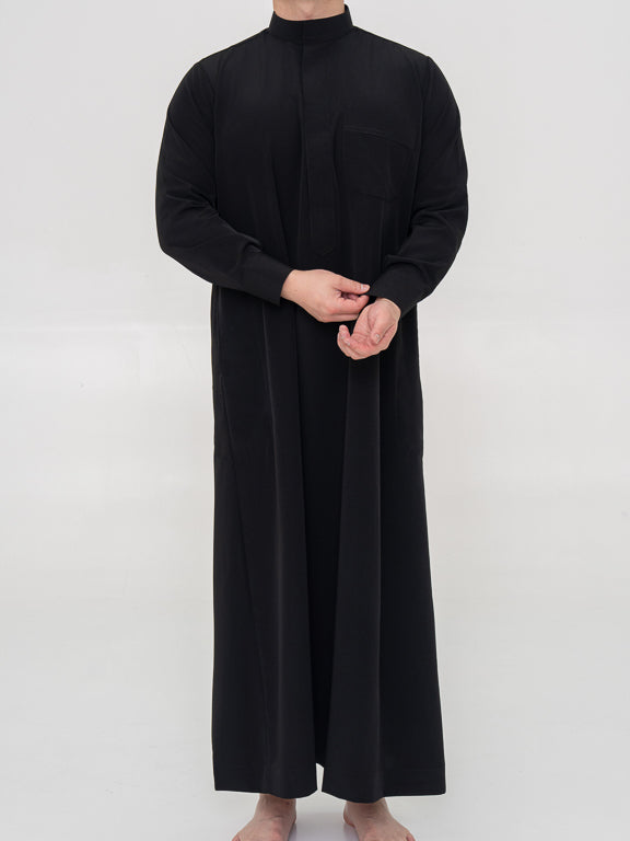 homme musulman portant un qamis saoudiehn noir de face