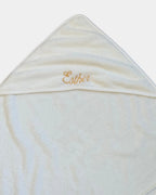 Détail de la broderie du prénom en fil doré sur la capuche de la serviette de bain bébé
