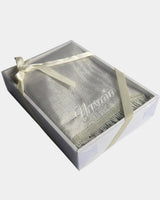 Tapis de prière en velours ivoire avec le prénom Yasmine brodé en fil blanc, présenté dans un coffret cadeau blanc noué d'un ruban ivoire assorti