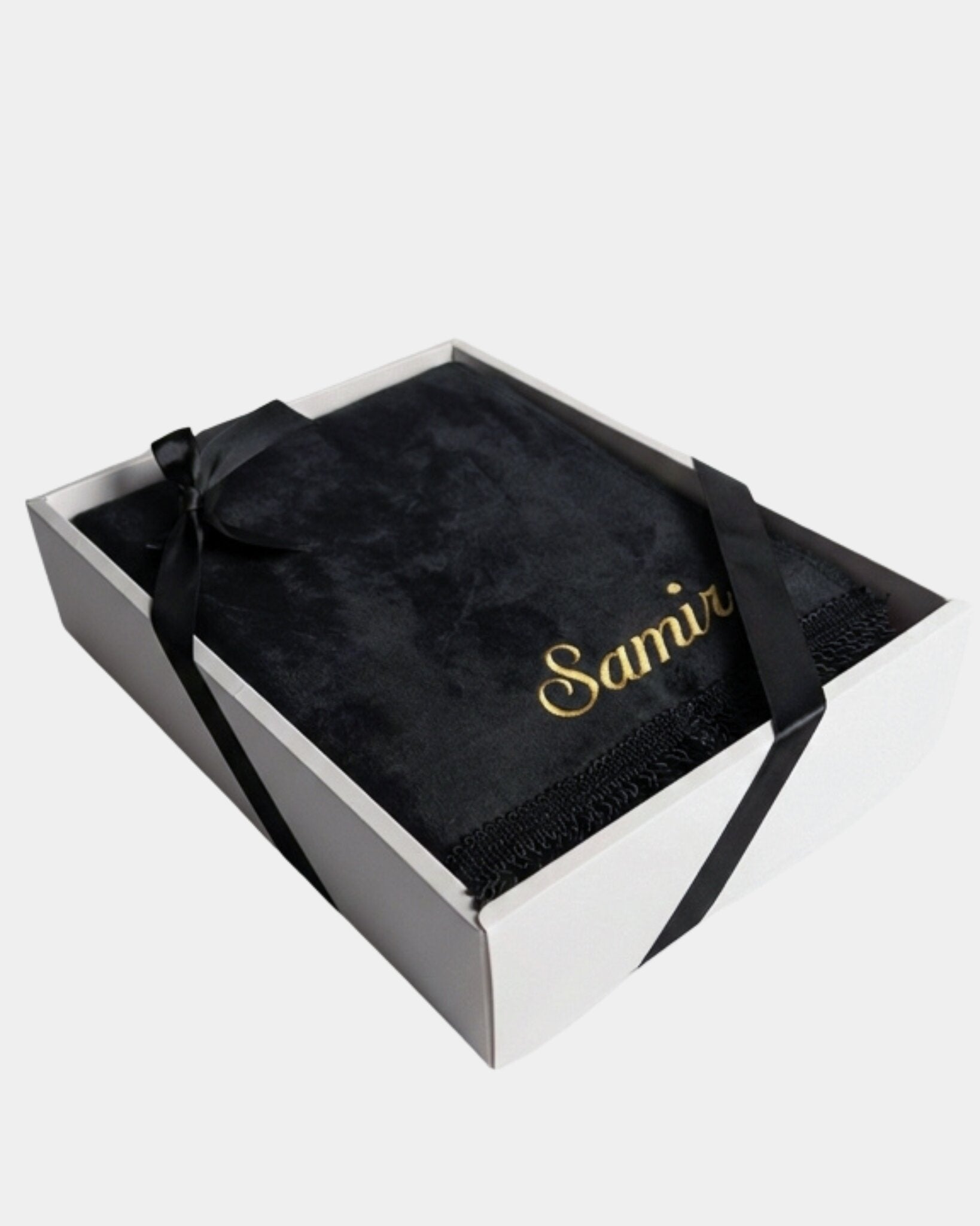 Tapis de prière en velours noir avec le prénom Samir brodé en fil doré, présenté dans un coffret cadeau blanc noué d'un ruban noir assorti