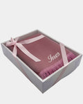 Tapis de prière en velours rose avec le prénom Ines brodé en fil blanc, présenté dans un coffret cadeau blanc noué d'un ruban rose assorti