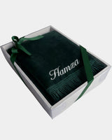 Tapis de prière en velours vert sapin avec le prénom Hamza brodé en fil blanc, présenté dans un coffret cadeau blanc noué d'un ruban vert assorti
